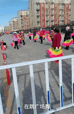 大妈跳广场舞把孩子栓栏杆上