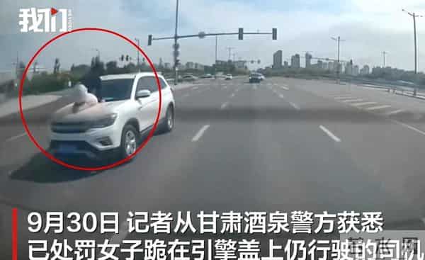 女子因感情纠纷爬上车头被顶行200米