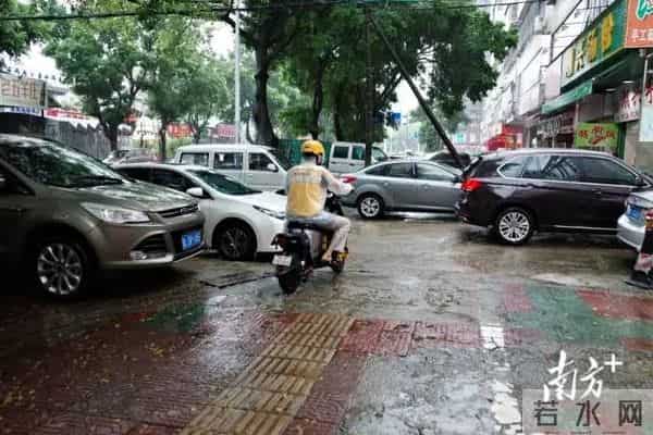 广东暴雨-街头积水市民骑车如渡河