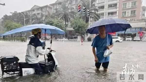 广东暴雨-街头积水市民骑车如渡河