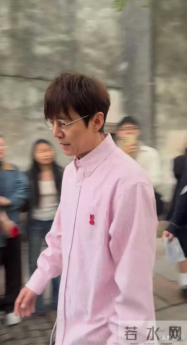 51岁何炅乌镇被偶遇，穿粉色条纹衬衣步伐矫健，带金丝眼镜显年轻