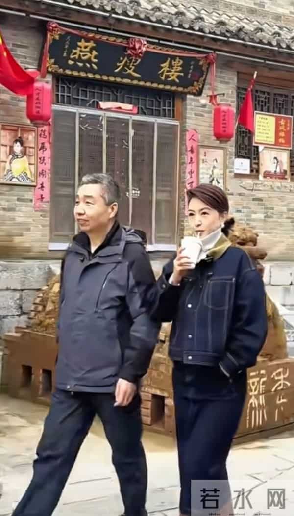 主持人张蕾边喝奶茶边走在古城街道上，46岁依旧美丽优雅！