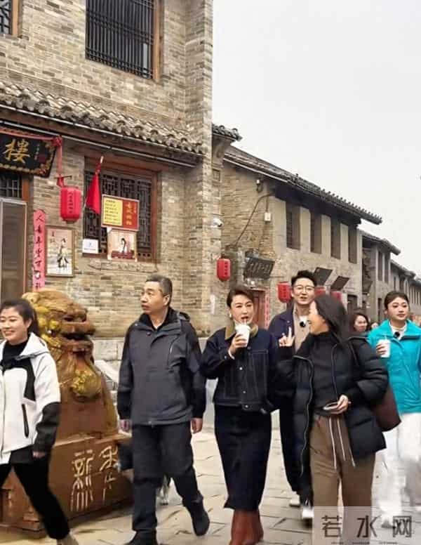 主持人张蕾边喝奶茶边走在古城街道上，46岁依旧美丽优雅！