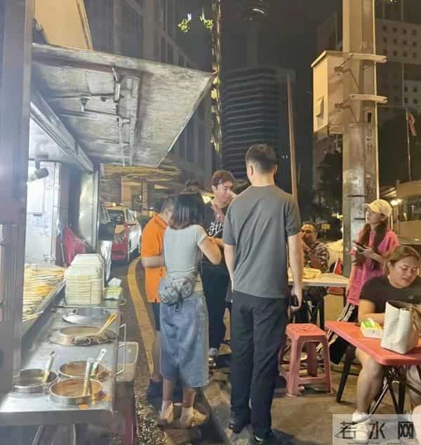 王思聪和朋友在吉隆坡吃大排档，他身穿灰色T恤长裤，穿着很低调