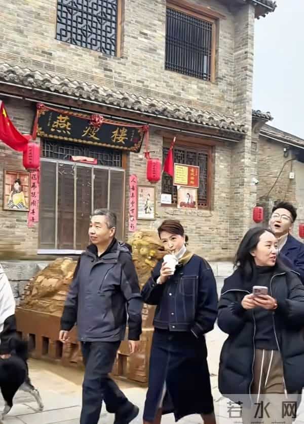 主持人张蕾边喝奶茶边走在古城街道上，46岁依旧美丽优雅！