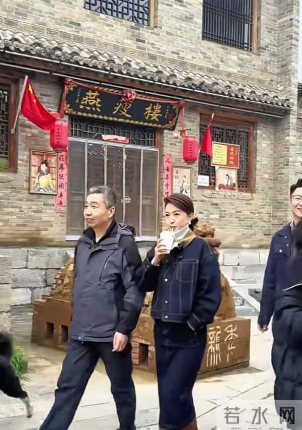 主持人张蕾边喝奶茶边走在古城街道上，46岁依旧美丽优雅！