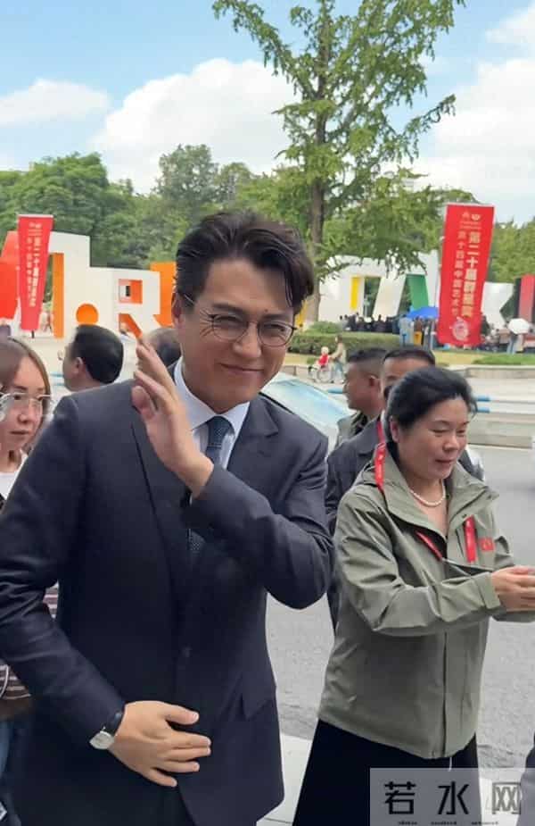 靳东重庆开会，路边走着被夸好帅，微笑招手回应，儒雅随和！