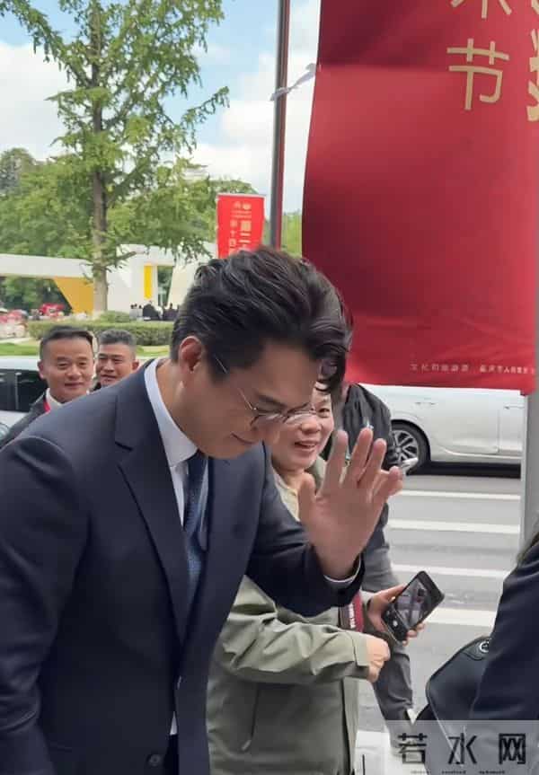 靳东重庆开会，路边走着被夸好帅，微笑招手回应，儒雅随和！
