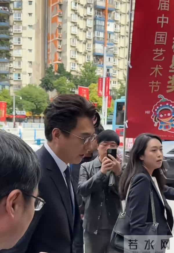 靳东重庆开会，路边走着被夸好帅，微笑招手回应，儒雅随和！