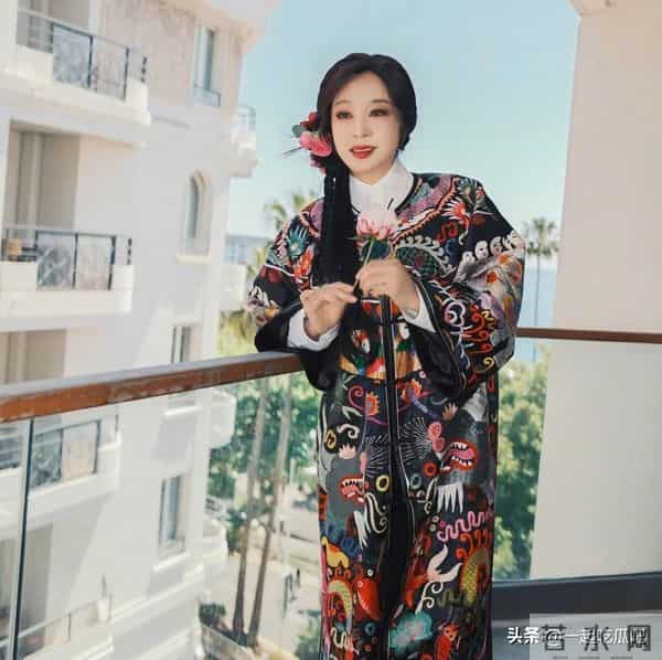 刘晓庆真的不服老啊，身穿黑色花纹袍子，头上别着几朵鲜花