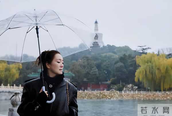 巩俐雨中撑伞漫步北海公园!湖边吃冰糖葫芦好惬意