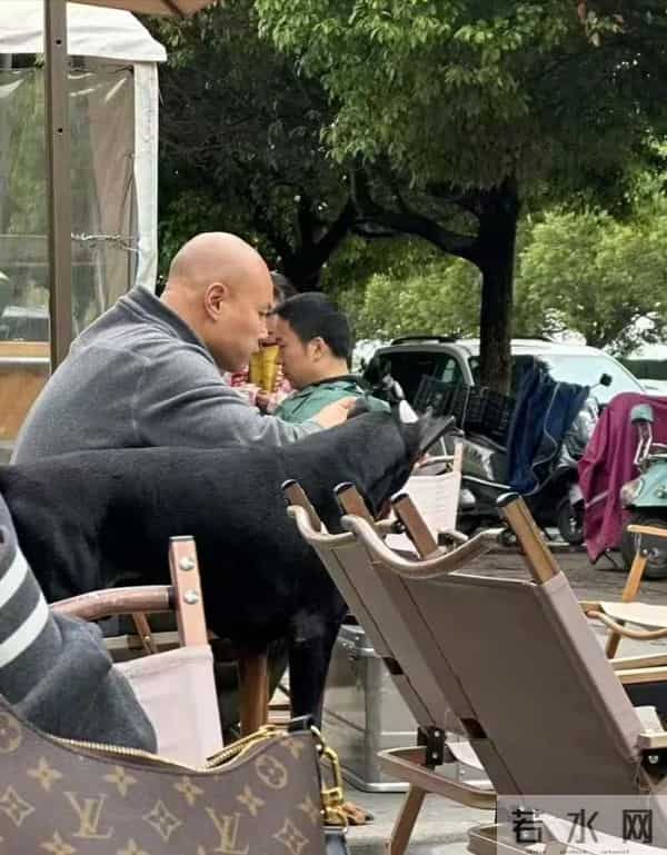 50岁乐嘉定居云南，牵着大狗外出，坐在路边看手机，生活非常悠闲