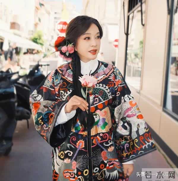 刘晓庆真的不服老啊，身穿黑色花纹袍子，头上别着几朵鲜花