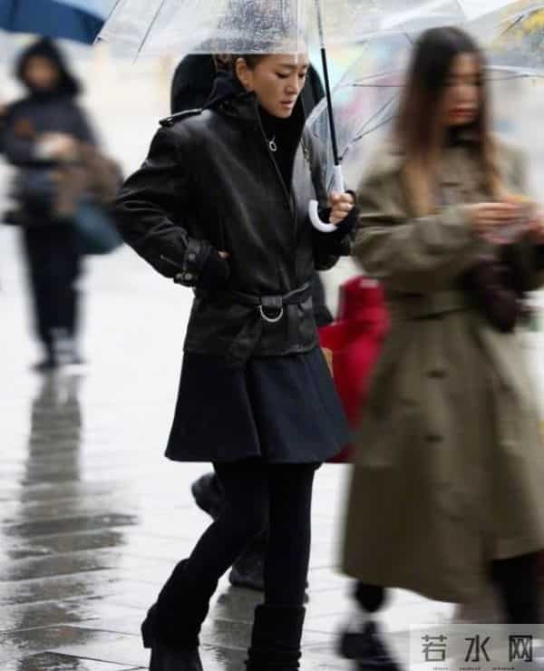 59岁巩俐现身北京公园，穿黑皮衣配透明伞，雨中喝酸奶吃冰糖葫芦