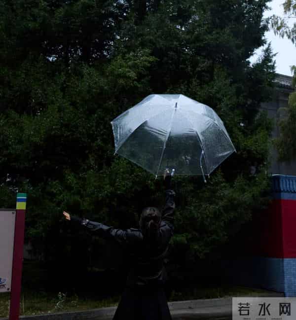59岁巩俐现身北京公园，穿黑皮衣配透明伞，雨中喝酸奶吃冰糖葫芦