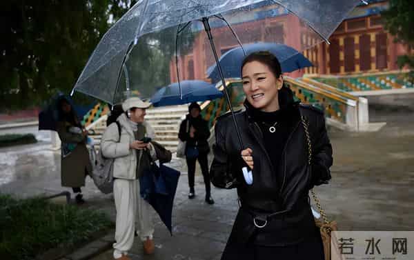 巩俐雨中撑伞漫步北海公园!湖边吃冰糖葫芦好惬意