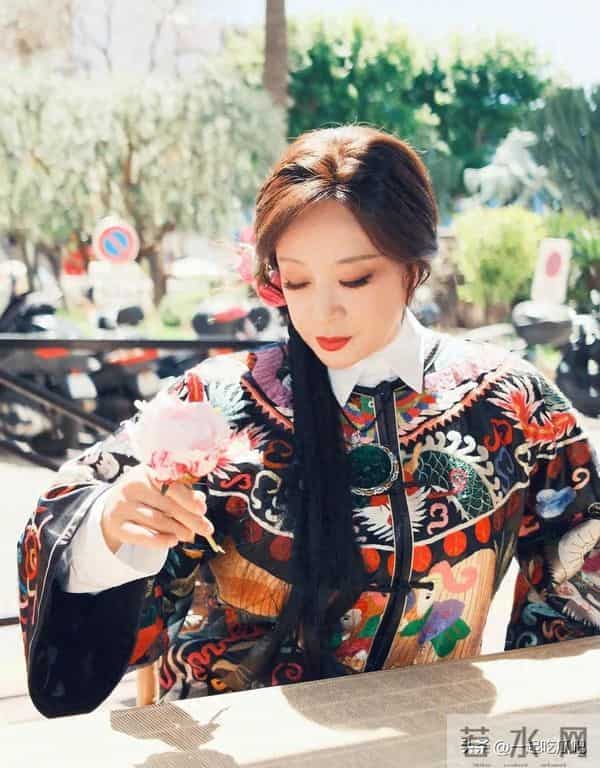 刘晓庆真的不服老啊，身穿黑色花纹袍子，头上别着几朵鲜花