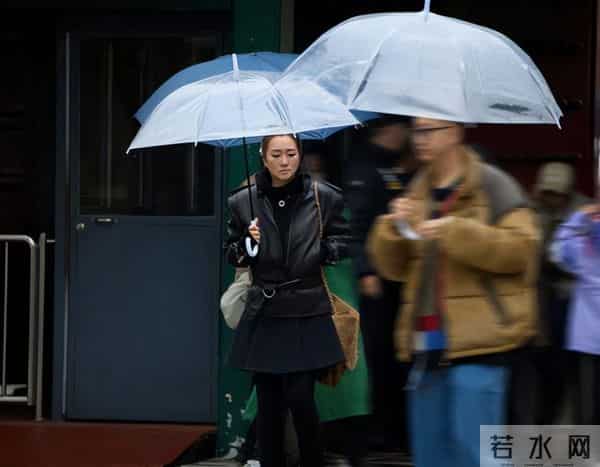 59岁巩俐现身北京公园，穿黑皮衣配透明伞，雨中喝酸奶吃冰糖葫芦