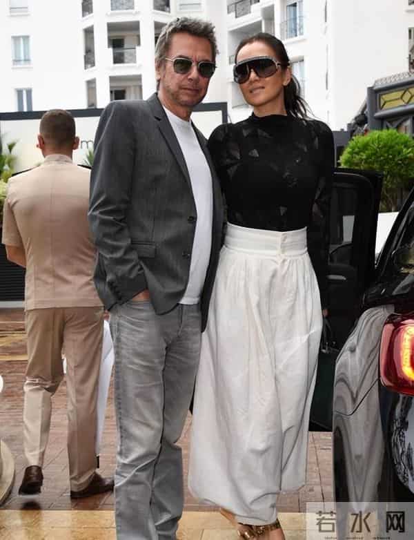 59岁巩俐现身北京公园，穿黑皮衣配透明伞，雨中喝酸奶吃冰糖葫芦