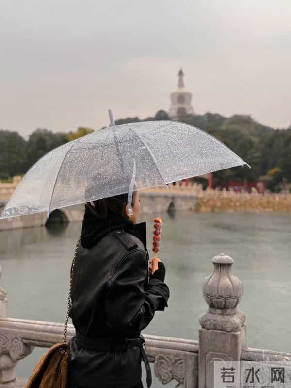 巩俐雨中撑伞漫步北海公园!湖边吃冰糖葫芦好惬意