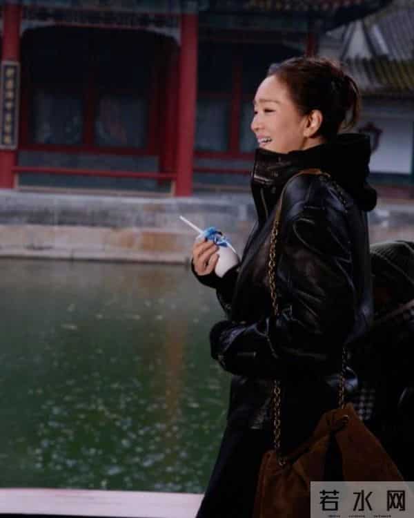 59岁巩俐现身北京公园，穿黑皮衣配透明伞，雨中喝酸奶吃冰糖葫芦