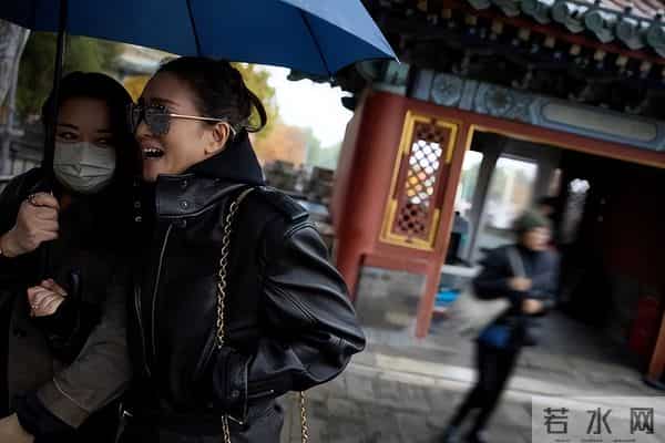 巩俐雨中撑伞漫步北海公园!湖边吃冰糖葫芦好惬意