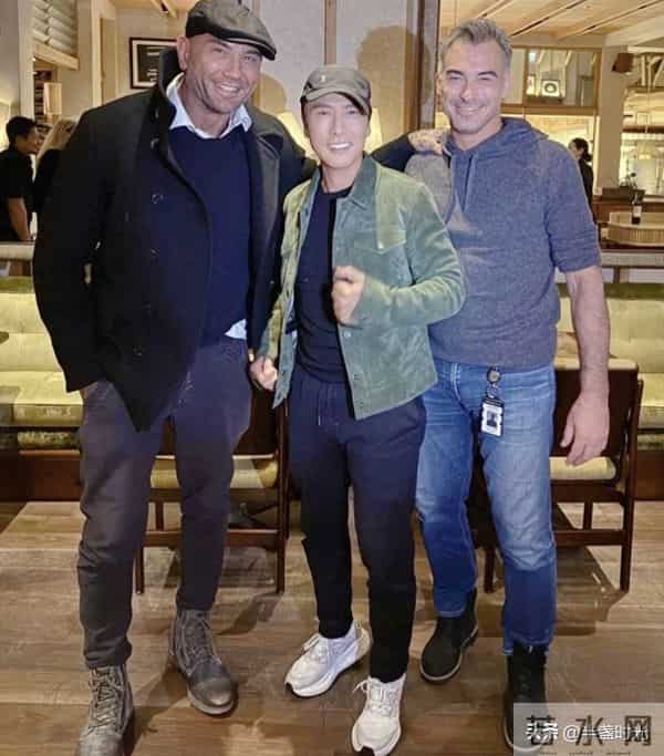 62岁甄子丹在英国和友人相聚，他穿着牛仔衣休闲裤，看着好年轻啊